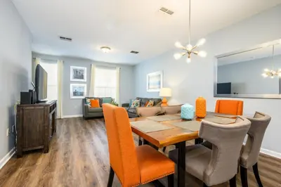 a dining room and living room with a table and chairs at Epic Universe New Modern Townhome, Near The Parks - 4029 in Orlando