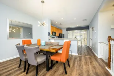 a kitchen and dining room with a table and chairs at Epic Universe New Modern Townhome, Near The Parks - 4029 in Orlando