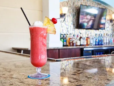 a drink in a glass sitting on top of a bar at Luxury Lakeview Penthouse, Vista Cay Orlando 1025 in Orlando