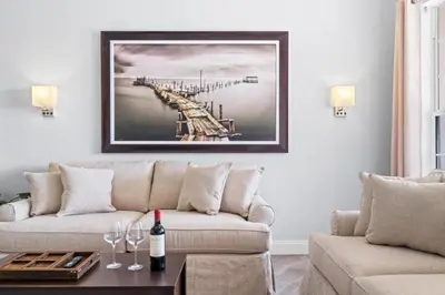 a living room with a couch and a picture of a pier at Luxury Lakeview Penthouse, Vista Cay Orlando 1025 in Orlando