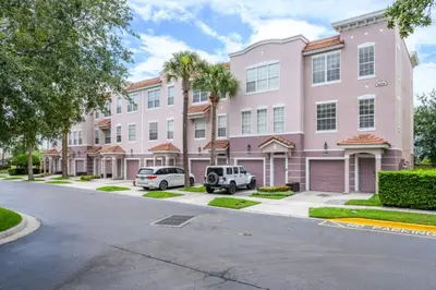 a pink building with two cars parked in front of it at New Modern Townhome, Near The Parks - 4030 in Orlando