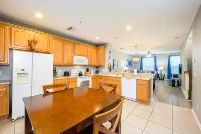 a kitchen with a wooden table and a white refrigerator at New Gorgeous Townhome, Epic Universe, Vista Cay - 4008 in Orlando