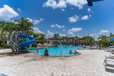 a pool at a resort with people in it at Cozy Retreat-Heated Pool, Grill, Pickle Ball, Gym in Kissimmee