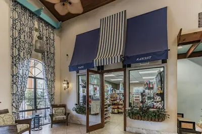 a store with blue and white awnings in a building at Cozy Retreat-Heated Pool, Grill, Pickle Ball, Gym in Kissimmee