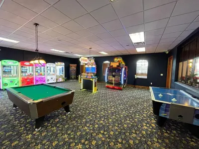 a room with several arcade games and a pool table at Cozy Retreat-Heated Pool, Grill, Pickle Ball, Gym in Kissimmee