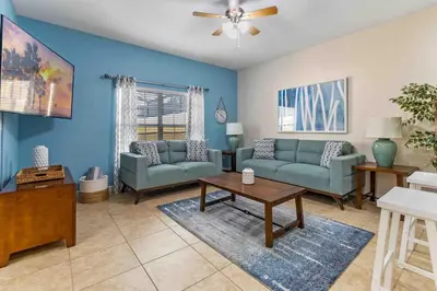 a living room with two couches and a table at Cozy Retreat-Heated Pool, Grill, Pickle Ball, Gym in Kissimmee