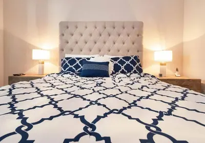a bedroom with a blue and white bed with two lamps at Conforto e Lazer a 7km da Disney – 2 Quartos in Kissimmee