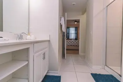 a white bathroom with a sink and a shower at Conforto e Lazer a 7km da Disney – 2 Quartos in Kissimmee