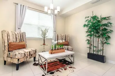 a living room with two chairs and a table at Conforto e Lazer a 7km da Disney – 2 Quartos in Kissimmee
