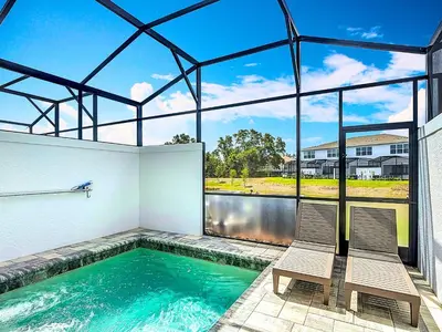 two chairs sitting next to a swimming pool in a house at Spacious 3BR with Clubhouses and Splash Fun in Orlando
