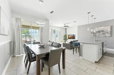 a dining room and living room with a table and chairs at Relax Near Disney 4BR Home with Pool in Kissimmee