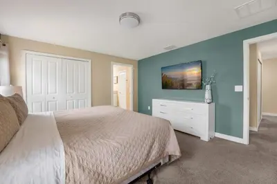 a bedroom with a white bed and a blue wall at Relax Near Disney 4BR Home with Pool in Kissimmee