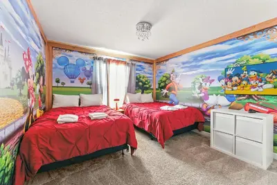 a bedroom with two beds and a painting on the wall at Relax Near Disney 4BR Home with Pool in Kissimmee