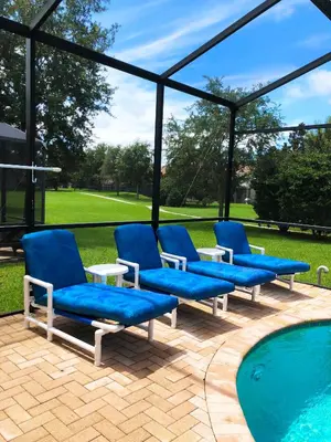 a group of blue chairs sitting next to a swimming pool at Windsor Hills Resort - Disney Dream Palace in Orlando