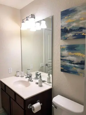a bathroom with a sink and a painting on the wall at Windsor Hills Resort - Disney Dream Palace in Orlando