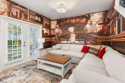 a living room with a white couch and a kitchen at 4BR Themed Home W Resort Pool Near Disney in Kissimmee