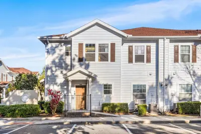 a white house with a gate at 4BR Themed Home W Resort Pool Near Disney in Kissimmee