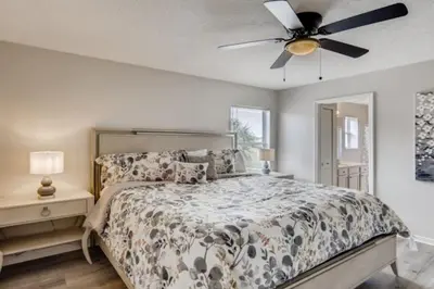 a bedroom with a bed and a ceiling fan at Lakefront 6BR Resort Pool Home Near Disney World in Kissimmee