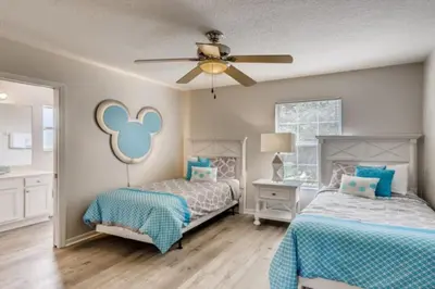 a bedroom with two beds and a ceiling fan at Lakefront 6BR Resort Pool Home Near Disney World in Kissimmee