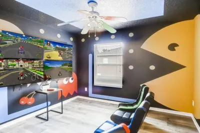 a room with a gaming room with two televisions at Lakefront 6BR Resort Pool Home Near Disney World in Kissimmee