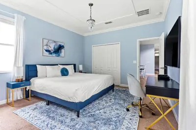 a blue bedroom with a bed and a desk at Lakefront 5BR Family Resort Pool Home Near Disney in Kissimmee