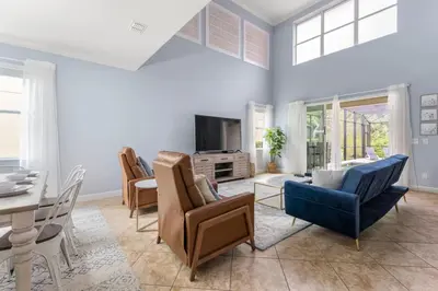 a living room filled with furniture and a table at Lakefront 5BR Family Resort Pool Home Near Disney in Kissimmee