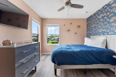 a bedroom with a blue bed and a window at Fantastic 5BR Themed Pool Home Near Disney World in Kissimmee