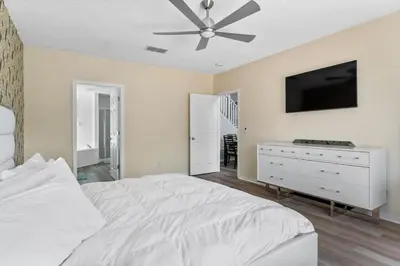 a bedroom with a white bed and a ceiling fan at Fantastic 5BR Themed Pool Home Near Disney World in Kissimmee