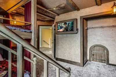 a room with a staircase with a tv on the wall at Magical 7BR Resort Pool Home Near Disney World in Kissimmee