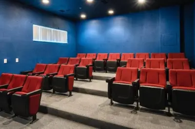an empty auditorium with red chairs and blue walls at Magical 7BR Resort Pool Home Near Disney World in Kissimmee