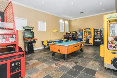 a room with a pool table and arcade games at Magical 7BR Resort Pool Home Near Disney World in Kissimmee