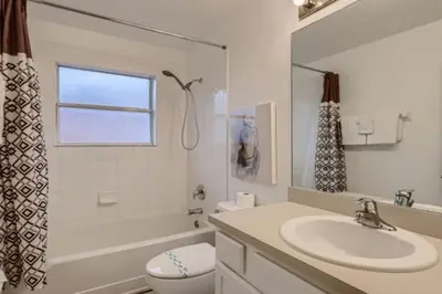 a white bathroom with a sink and a toilet at Magical 7BR Resort Pool Home Near Disney World in Kissimmee
