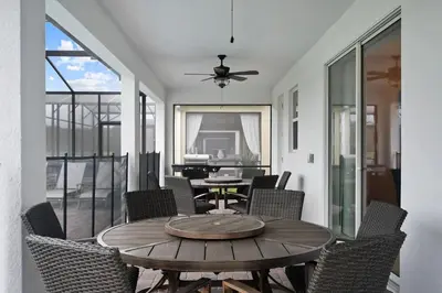 a patio with a wooden table and chairs at Vila incrível 9 quartos | Perto da Disney in Kissimmee
