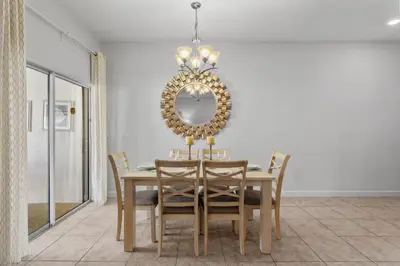 a dining room with a table and a mirror at 4BR Townhome with Pool at Storey Lake in Kissimmee
