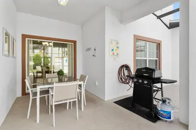 a dining room with a table and chairs and a stove at 4BR Townhome with Pool at Storey Lake in Kissimmee