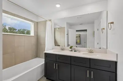 a bathroom with two sinks and a tub and a mirror at Stylish Family Retreat with Themed Bedrooms in Kissimmee