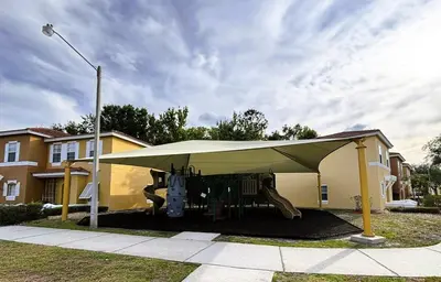 a tent with a playground in front of a house at Relax and unwind in this Cozy Home Away from Home in Kissimmee