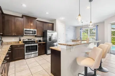 a kitchen with stainless steel appliances and wooden cabinets at Fantastic 6BR Themed Encore Home in Orlando