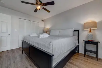 a bedroom with a large bed with a ceiling fan at Charming and Cozy Townhome Near Disney in Kissimmee