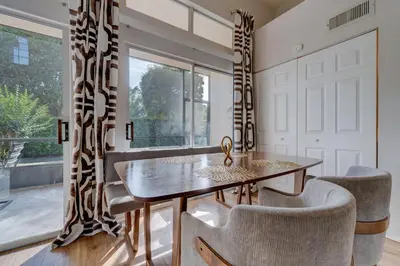 a dining room with a table and chairs and a window at Charming and Cozy Townhome Near Disney in Kissimmee