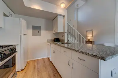 a kitchen with white cabinets and a counter top at Charming and Cozy Townhome Near Disney in Kissimmee