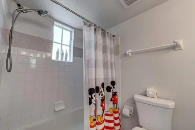 a bathroom with a toilet and a shower with a shower curtain at Charming and Cozy Townhome Near Disney in Kissimmee