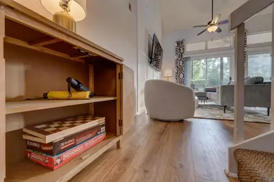a room with a chair and a desk with books at Charming and Cozy Townhome Near Disney in Kissimmee