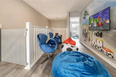 a room with two blue chairs and a tv at The Minions Mansion 6br Resort Pool Home By Disney in Kissimmee
