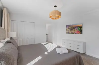 a white bedroom with a bed and a lamp at 2645 Casa Luxuosa com Piscina Privativa perto da Disney in Kissimmee