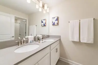 a bathroom with two sinks and a large mirror at Casa 4 Quartos com Piscina Privativa Storey Lake in Kissimmee