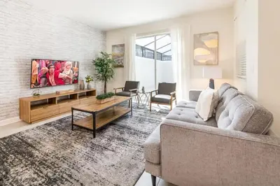 a living room with a couch and a tv at Casa 4 Quartos com Piscina Privativa Storey Lake in Kissimmee
