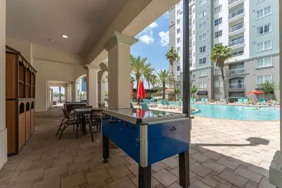 a ping pong table in the middle of a patio with a pool at Cozy Apartment w Kitchen Near Universal in Orlando