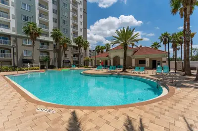 a swimming pool in a resort with palm trees and buildings at Combined units 2 Kitchens Sleeps 6 in Orlando