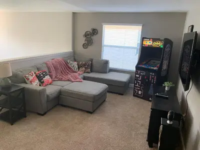 a living room with a gray couch and a video game at Relaxing Villa very close to Disney and Universal in Kissimmee